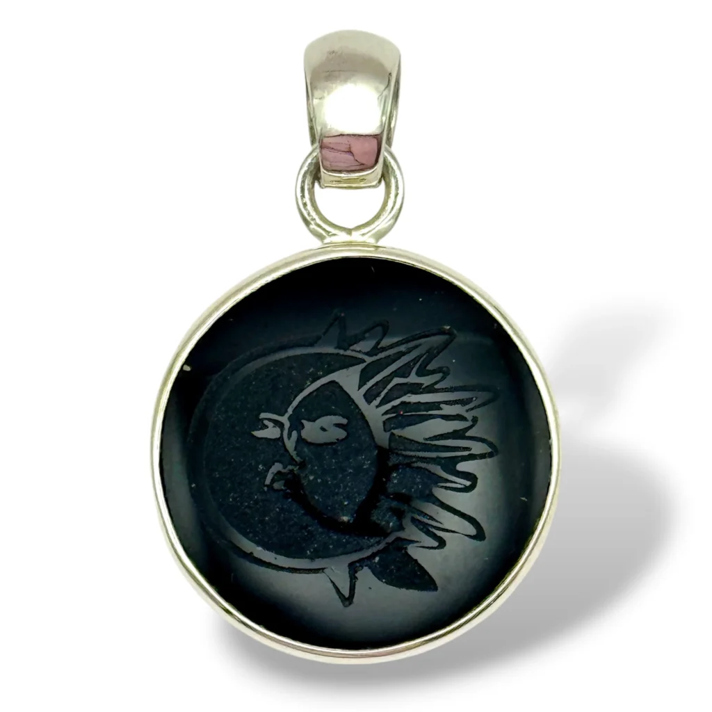 Dije de Plata con Obsidiana negra grabada con Sol y Luna. Diámetro 2 cm.