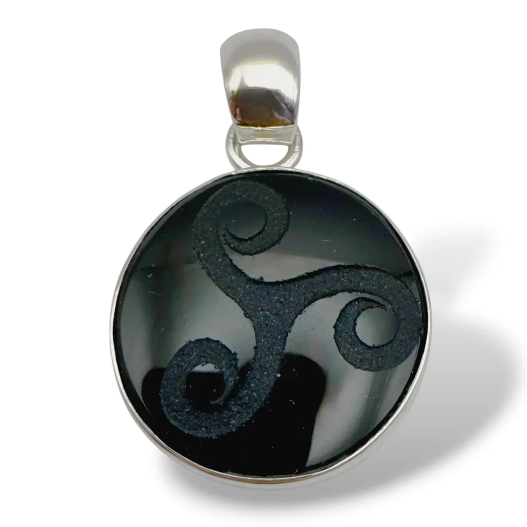 Dije de Plata con Obsidiana negra con Triskel grabado. Diámetro 2 cm.